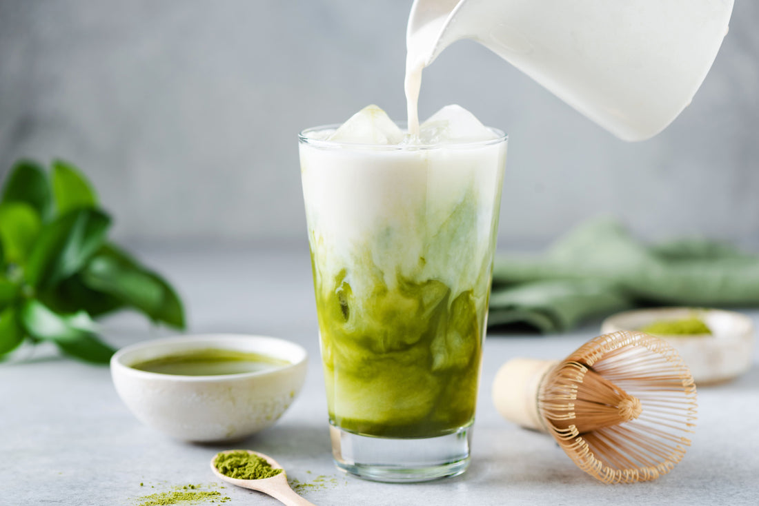 Matcha Latte Zubereitung mit aufgeschäumter Milch und Matcha Pulver