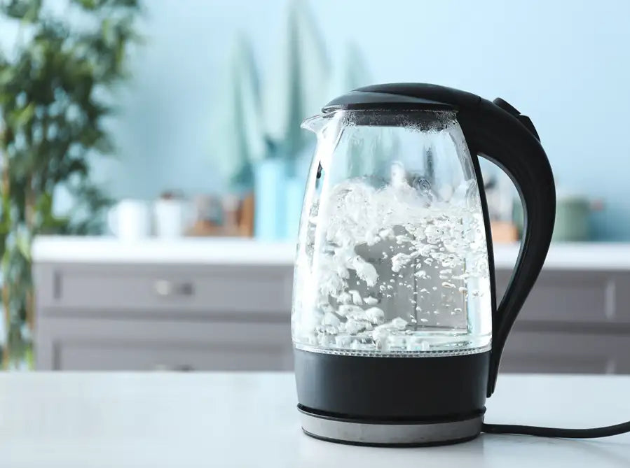 Klare Glas-Elektro-Kanne mit schwarzen Akzenten und Kabel, modernes Design.